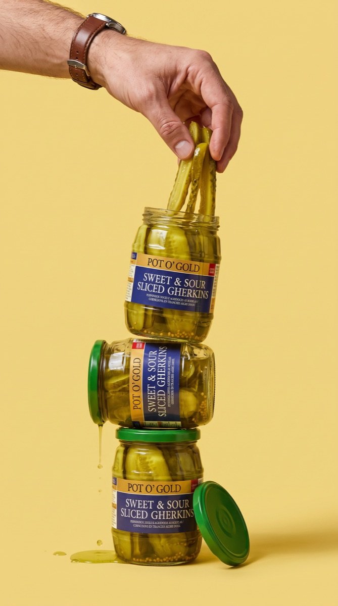 Hand lifting lengthwise slices from Pot O’ Gold jars